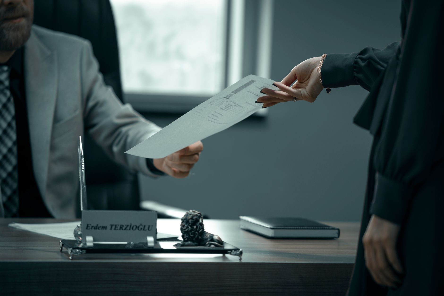 Dois profissionais trocando documentos em ambiente de escritório, representando a necessidade de guardar cópia de documentos trabalhistas