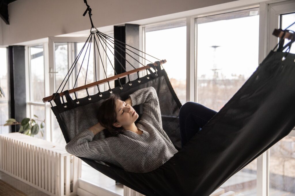 Mulher descansando em uma rede ao ar livre, representando o descanso semanal remunerado
