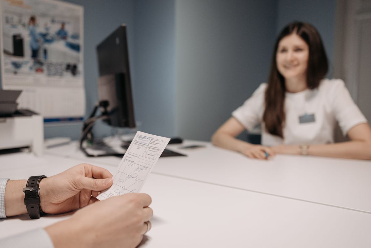 Médica orientando paciente com receita em consultório
