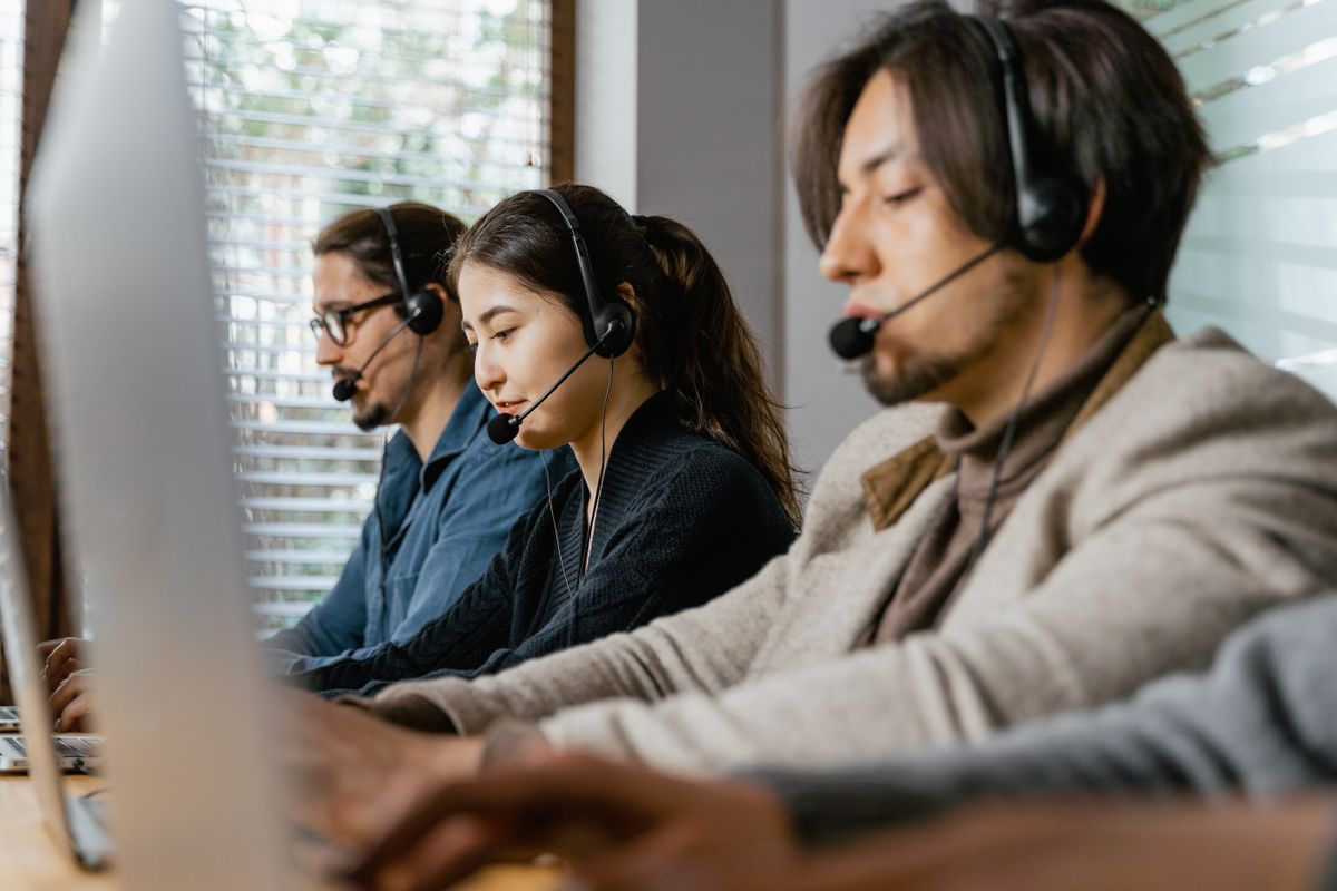 Operadoras de telemarketing trabalhando com headsets em central de atendimento