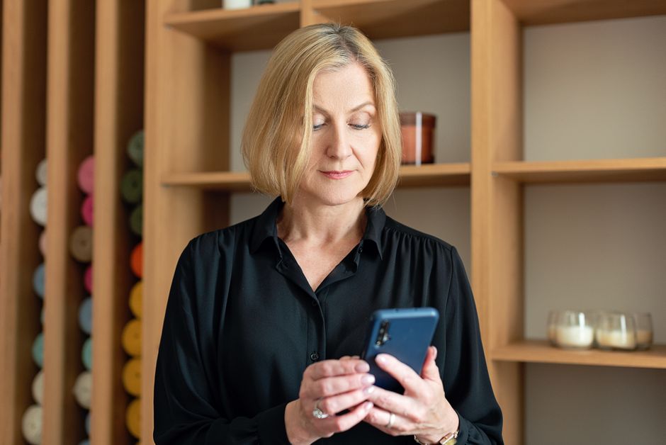 Trabalhadora consultando mensagens no celular, prova digital de jornada