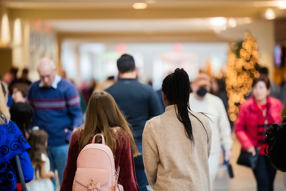 Shopping lotado de clientes em época de promoções, com trabalhadores do comércio atendendo