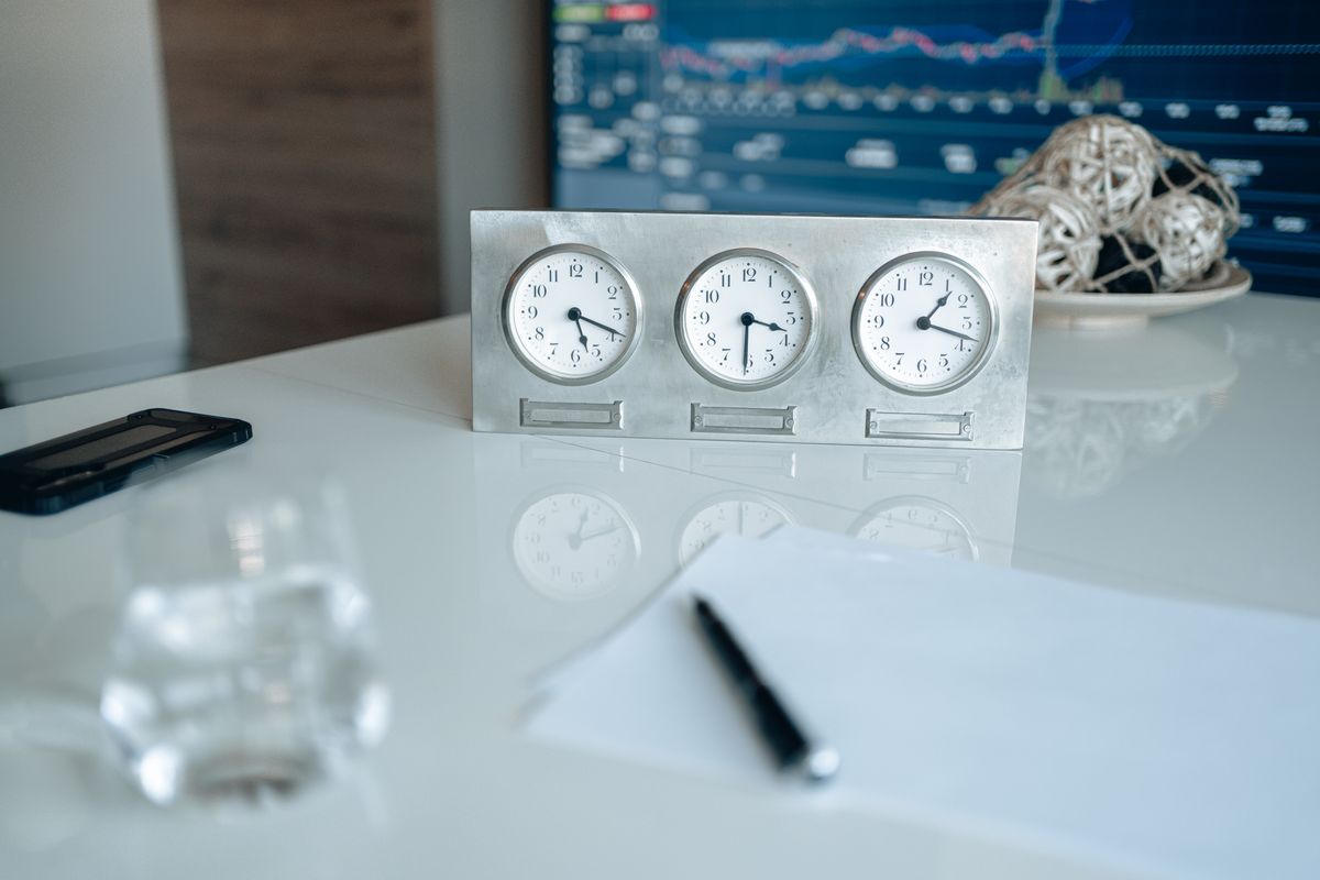 Mesa de trabalho com três relógios e dados na tela