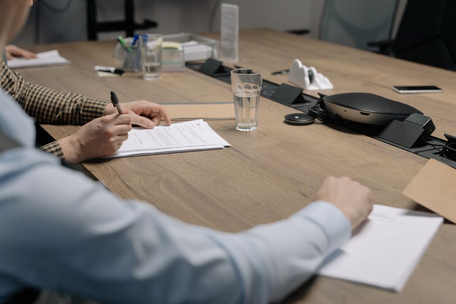 Profissionais assinando documentos durante reunião