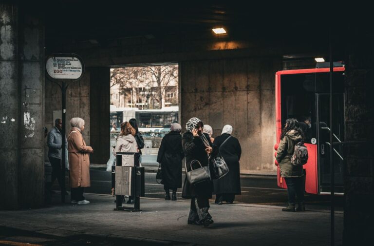 Pessoas esperando ônibus em ponto urbano a caminho do trabalho